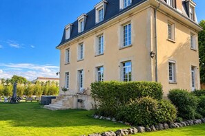 A large, two-story building with a symmetrical facade, multiple windows, and a well-maintained lawn with a stone border. - Hôtel Particulier d'Exception Champagne Experience - 5 minutes from Reims (cernay les reims)