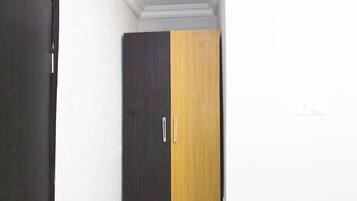 A wardrobe with two doors, one dark and one light, in a room with white walls and a white ceiling.
