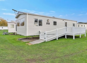 A mobile home with a white exterior, a front porch, and a small attached garage. - Vacant Nests | Seton sands | St Andrews (Longniddry)