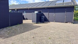A building with a dark exterior, a flat roof, and a paved driveway. - 4 Star Holiday Home in Karrebaeksminde (Karrebæksminde)