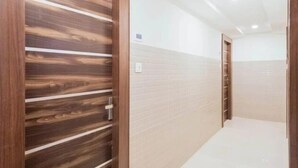 Un pasillo con una puerta de madera y un revestimiento de baldosas.