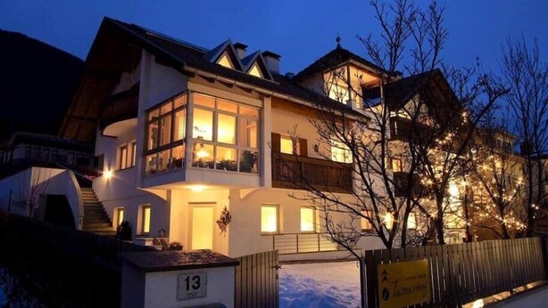 A multi-story hotel with a balcony on the second floor, a mailbox with the number 13, and a sign indicating a ski resort. - Appartment with beautiful mountain view (San Giorgio)