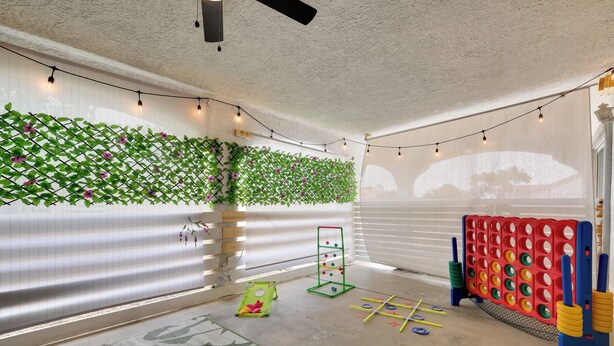 A playroom with a green climbing wall, a small slide, and a tic-tac-toe game. - Patio & Yard: 'the Goat House' Vegas Retreat (Las Vegas)