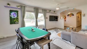 A room with a green felt table, a sofa, a TV, and a plant wall. - Patio & Yard: 'the Goat House' Vegas Retreat (Las Vegas)