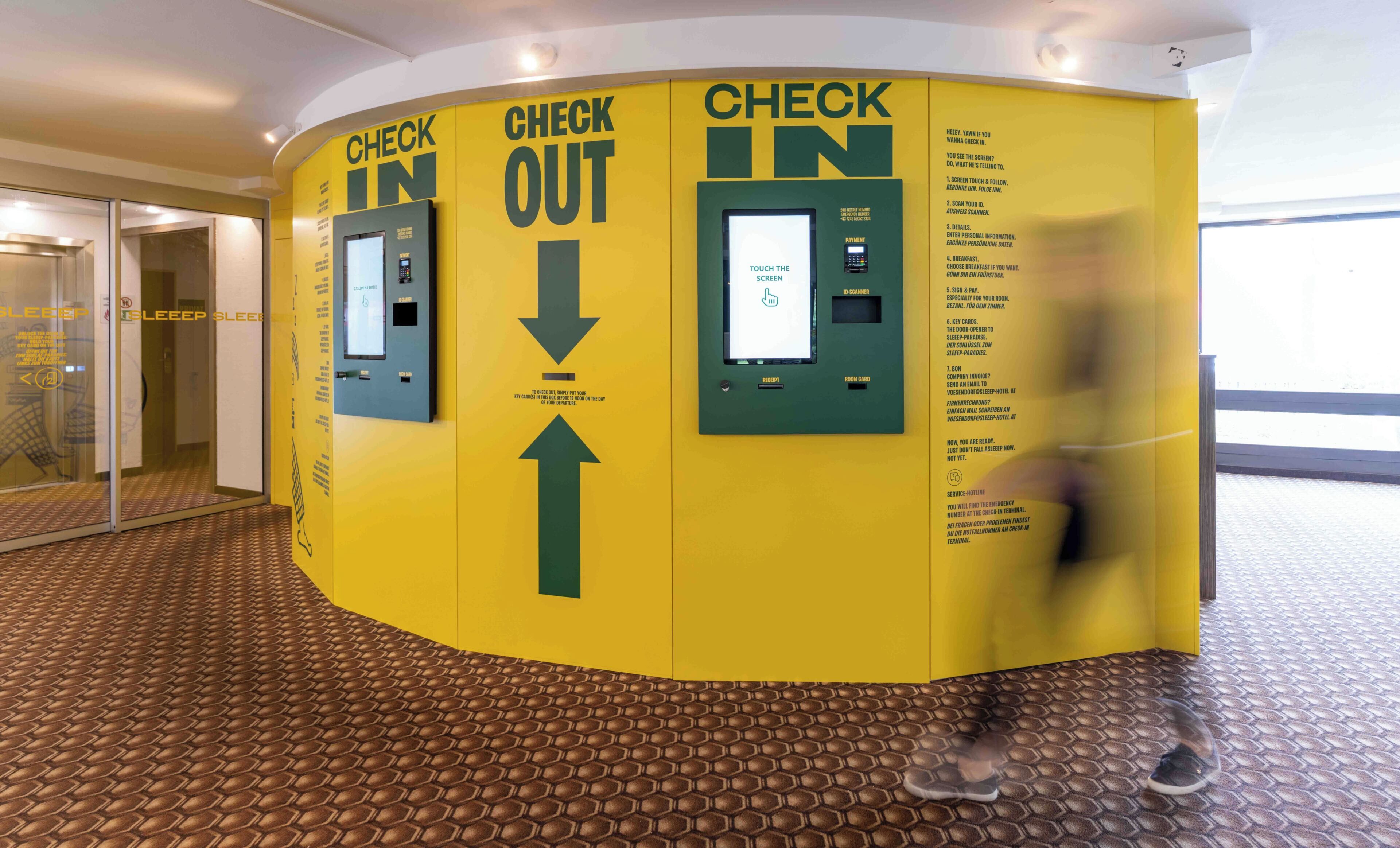 A hotel check-in/out kiosk with directional arrows and instructions for guests.
