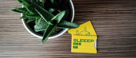 A potted plant on a wooden surface with a yellow note indicating a sleep room.
