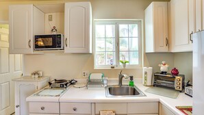 A kitchen with white cabinets, a microwave, a toaster, and a sink. - Cozy Couple's Oasis w/ Pool: 3 Mi to Disneyland! (Garden Grove)