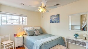 A bedroom with a bed, nightstand, chair, and a ceiling fan. - Cozy Couple's Oasis w/ Pool: 3 Mi to Disneyland! (Garden Grove)