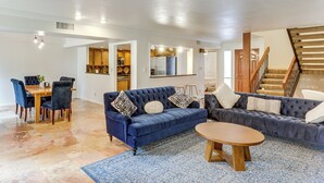 A spacious living room with a blue sofa, a wooden coffee table, and a dining area with a wooden table and chairs. - 5 Mi to Colorado River: Yuma Gem w/ Pool Access! (Yuma)
