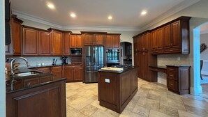 Una cocina moderna con armarios de madera, electrodomésticos de acero inoxidable y una isla central.