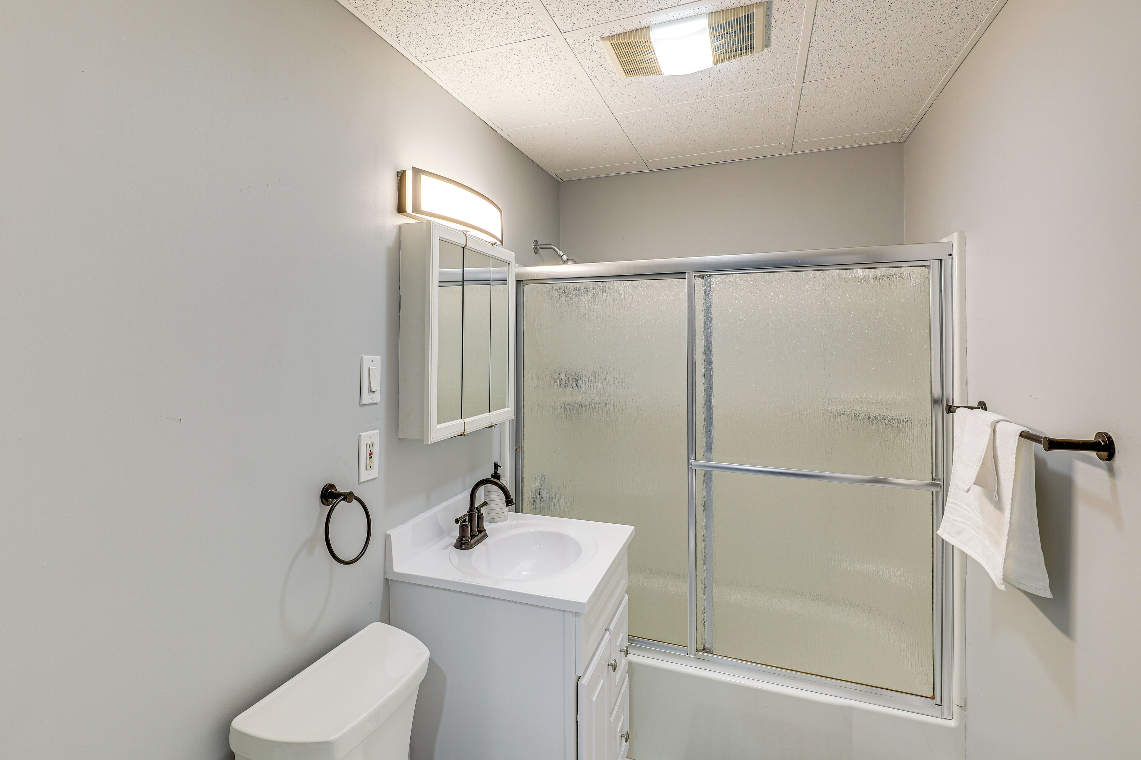Bagno con toilette, lavandino e cabina doccia con vetro satinato.