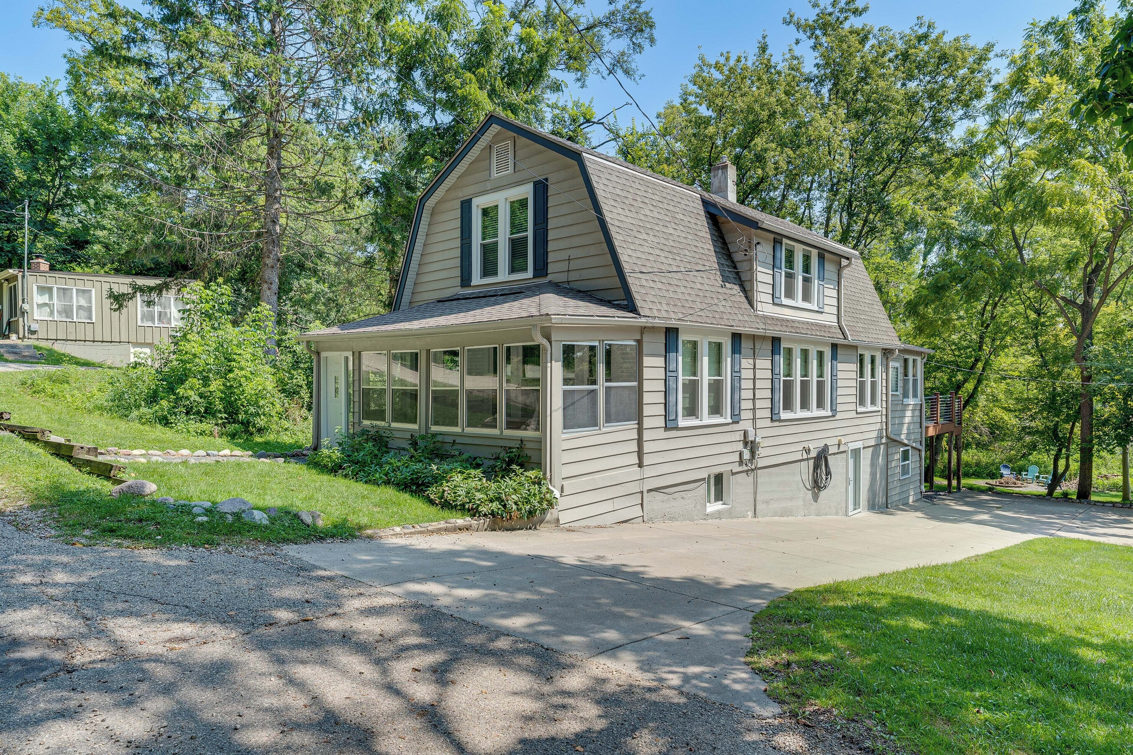 A two-story house with a large front porch, a covered entryway, and a sloped roof.