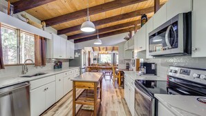 Una cocina moderna con vigas de madera, electrodomésticos de acero inoxidable y una isla central.