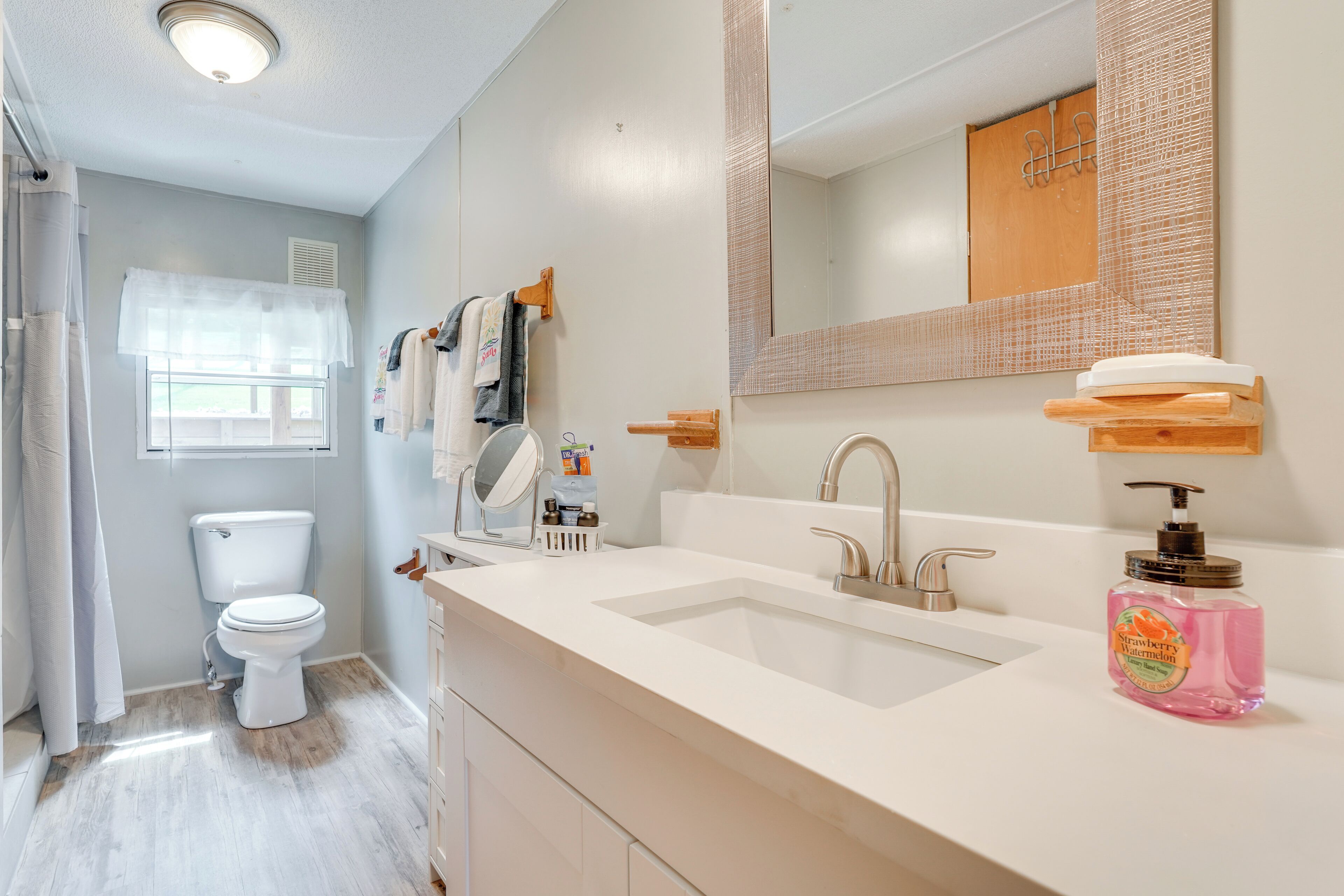 A modern bathroom with a toilet, sink, and mirror.