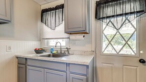A kitchen with a sink, cabinets, and a window with blinds. - 3 Mi to Dtwn & Flood Museum: 'cozy Q Cottage' (Johnstown)