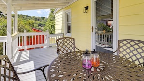 A covered patio with a round metal table, two chairs, and two glass jars with liquids. - 3 Mi to Dtwn & Flood Museum: 'cozy Q Cottage' (Johnstown)