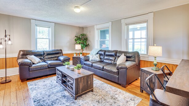A spacious living room with two leather sofas, a coffee table, and a dining table. - < 1 Mi to Lake: Mtn-view Cabin w/ Porch in Newport (Newport)