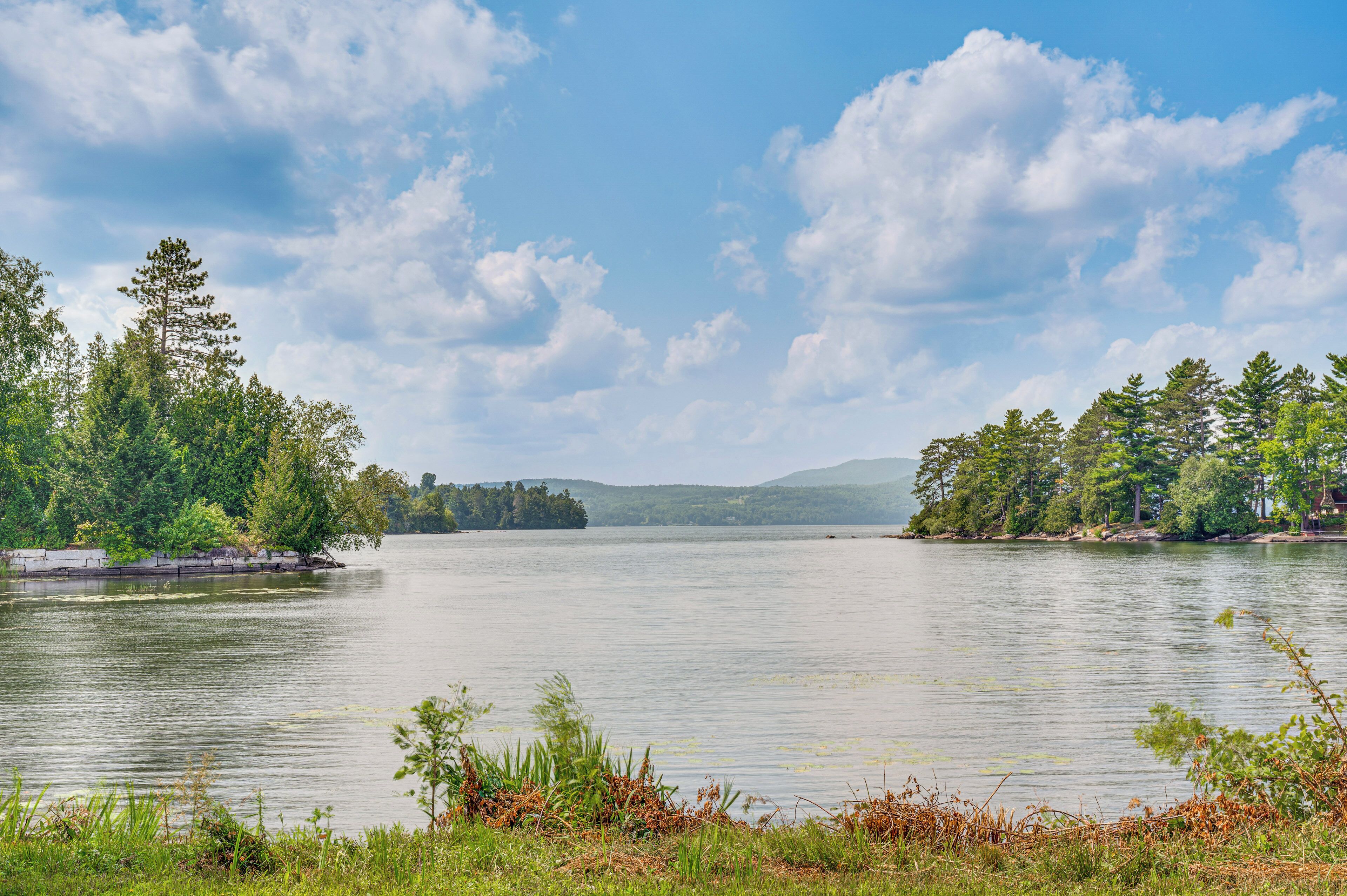 A calm lake with trees on both sides and a clear sky.