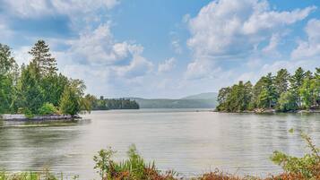 A calm lake with trees on both sides and a clear sky.