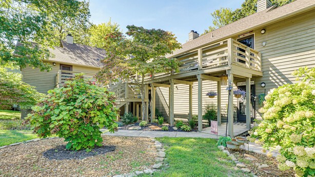 A two-story house with a covered porch, a small garden with a variety of plants, and a clear sky. - Hike, Fish & Golf: Condo 5 Mi to Ozone Falls! (Crab Orchard)