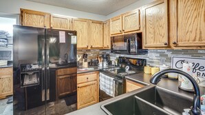 A modern kitchen with wooden cabinets, stainless steel appliances, and a built-in water dispenser. - Hike, Fish & Golf: Condo 5 Mi to Ozone Falls! (Crab Orchard)