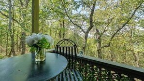A table with a vase of flowers on a balcony with a view of a forest. - Hike, Fish & Golf: Condo 5 Mi to Ozone Falls! (Crab Orchard)