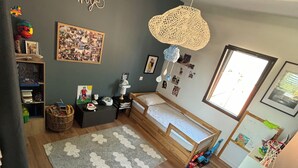 A child's bedroom with a bunk bed, a woven light fixture, a wall collage, and a large window. - Villa house Blondin (Ucel)