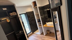 A modern bathroom with black and white cabinetry, a black sink, and a wooden floor. - Villa house Blondin (Ucel)