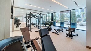 Ein modernes Fitnessstudio mit Trainingsgeräten, großen Fenstern und Blick auf die Straße.