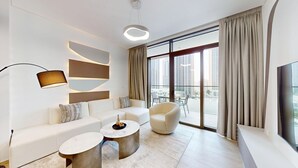 Ein modernes Wohnzimmer mit einer Couch, zwei Sesseln, einem Couchtisch und einem großen Fenster mit Vorhängen.