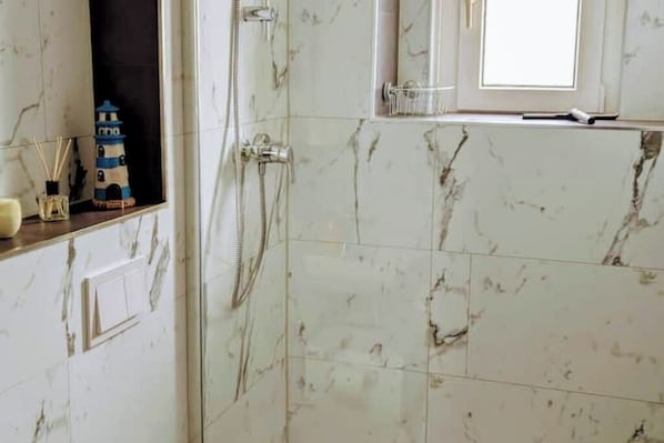Chuveiro, secador de cabelo, toalhas de banho, sabonete
