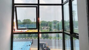 A room with a large window overlooking a construction site. - Royal Galaxy Hotel (Shri Madhopur)