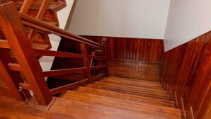 A wooden staircase with a handrail and a white wall at the top. - 3LDK, 2 private rooms, 1 shared room, spacious kitchen, meeting room, and parking space. (Nagarjun, Kathmandu, Bagmati)