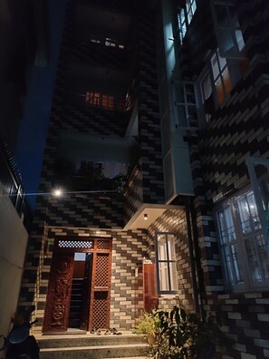 A multi-story building with a patterned facade and a central entrance with decorative elements. - 3LDK, 2 private rooms, 1 common room, spacious kitchen, meeting room, and parking space. (Nagarjun, Kathmandu, Bagmati)