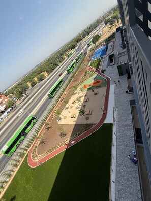 Vista aèria d'una zona enjardinada amb una pista d'atletisme, bancs i un parc infantil.