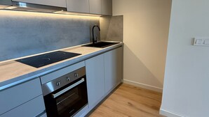 Una cucina moderna con forno integrato, lavello e cappa aspirante.