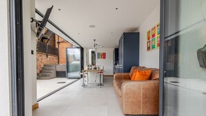 Una sala de estar moderna con sofá, una mesa de comedor y una zona de cocina.