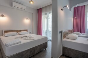 A hotel room with two beds, a large window with sheer curtains, an air conditioning unit, and wall-mounted lighting. - BEST ALANYA OTEL (Alanya)