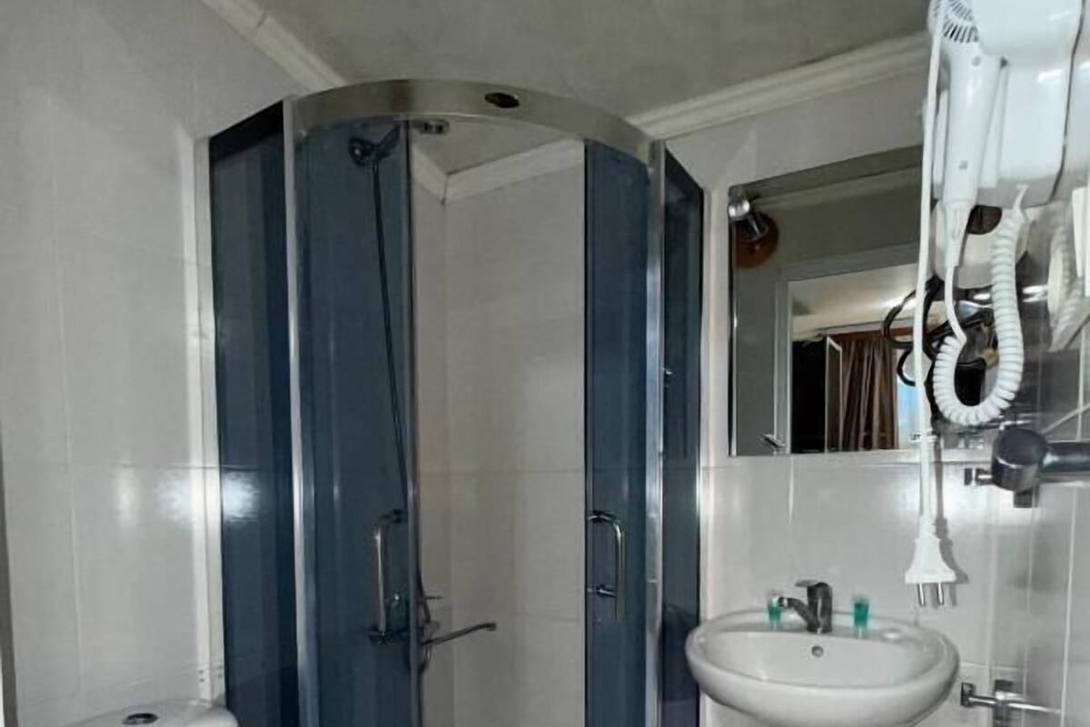 A bathroom with a toilet, a sink, and a shower enclosure.