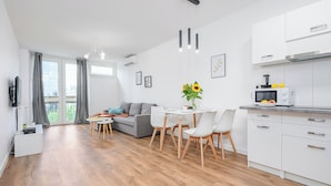 A modern apartment with a dining area, kitchen, and living room. - ShortStayPoland Jana Pawla B90 (Warsaw)