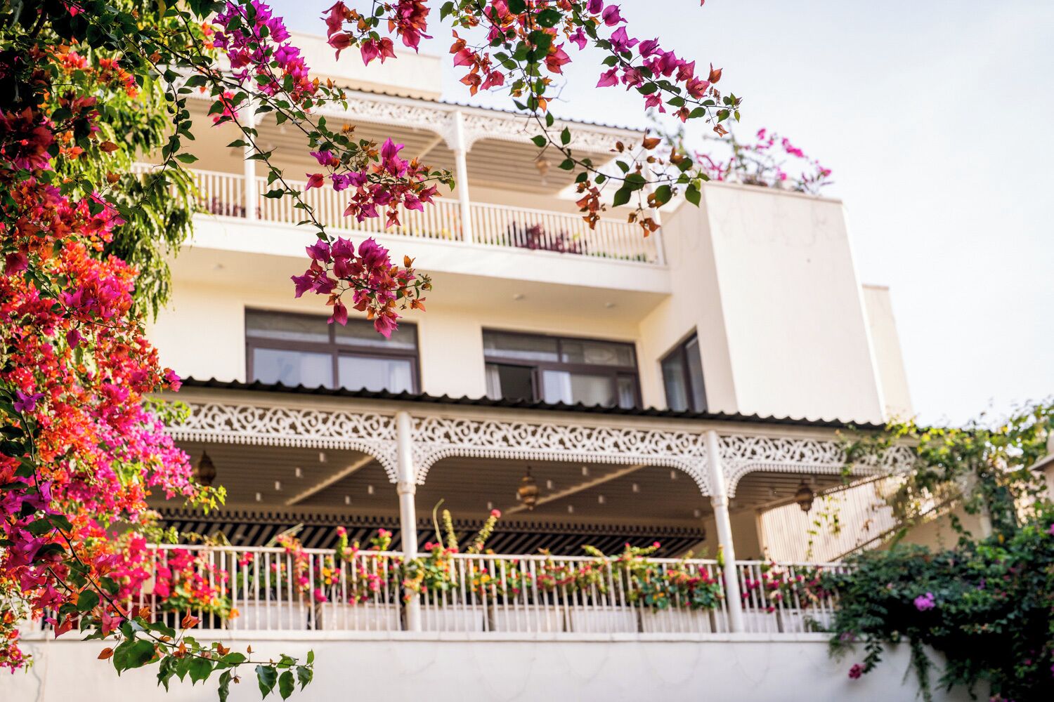 A multi-story building with balconies adorned with flowers.