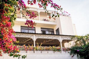 Un edificio de varios pisos con balcones decorados con flores.