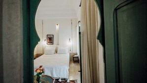 Une chambre à coucher avec un grand lit, une table de chevet, une lampe et un tableau encadré au mur.