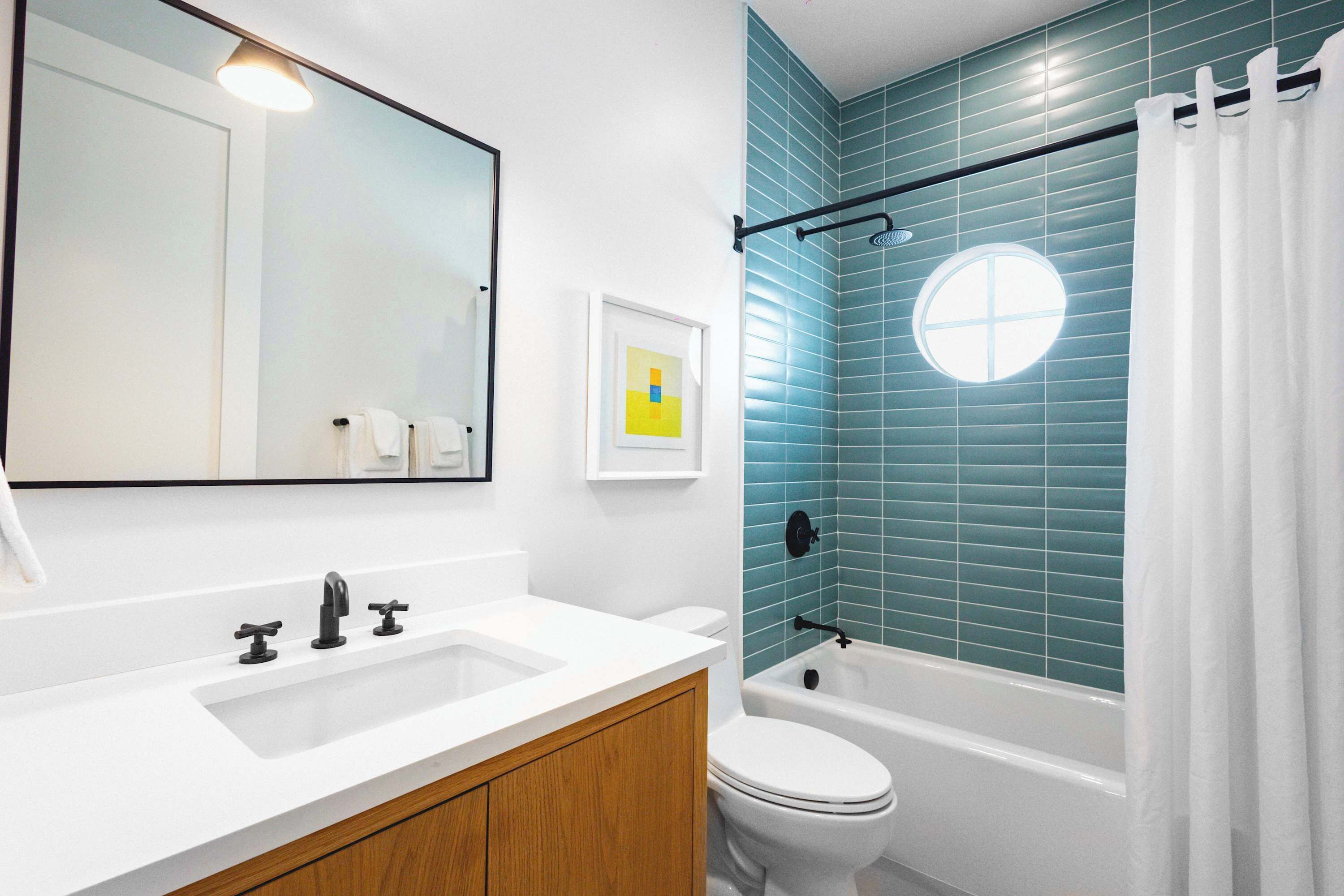 Une salle de bain avec un lavabo blanc, des toilettes et une baignoire.