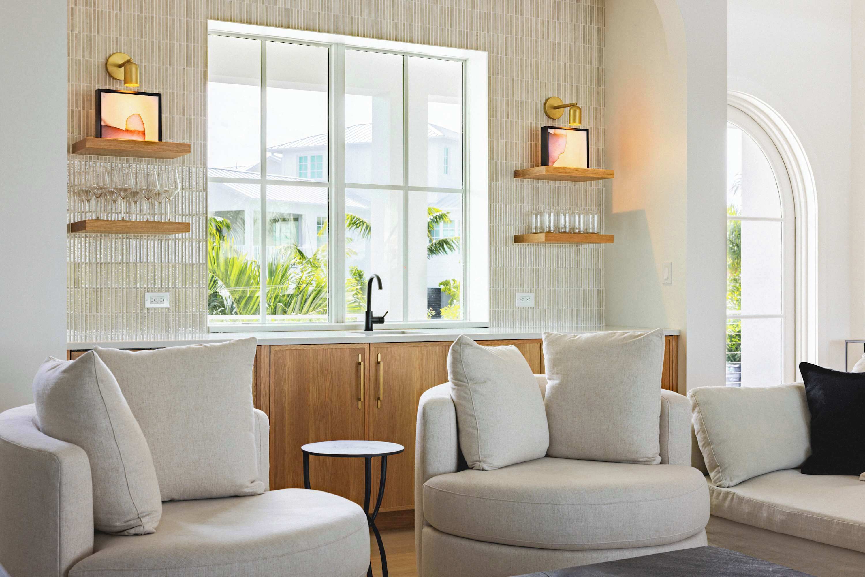 A modern living room with a large window, built-in shelves, and a small round table.