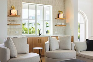 Un salon moderne doté d’une grande fenêtre, d’étagères intégrées et d’une petite table ronde.