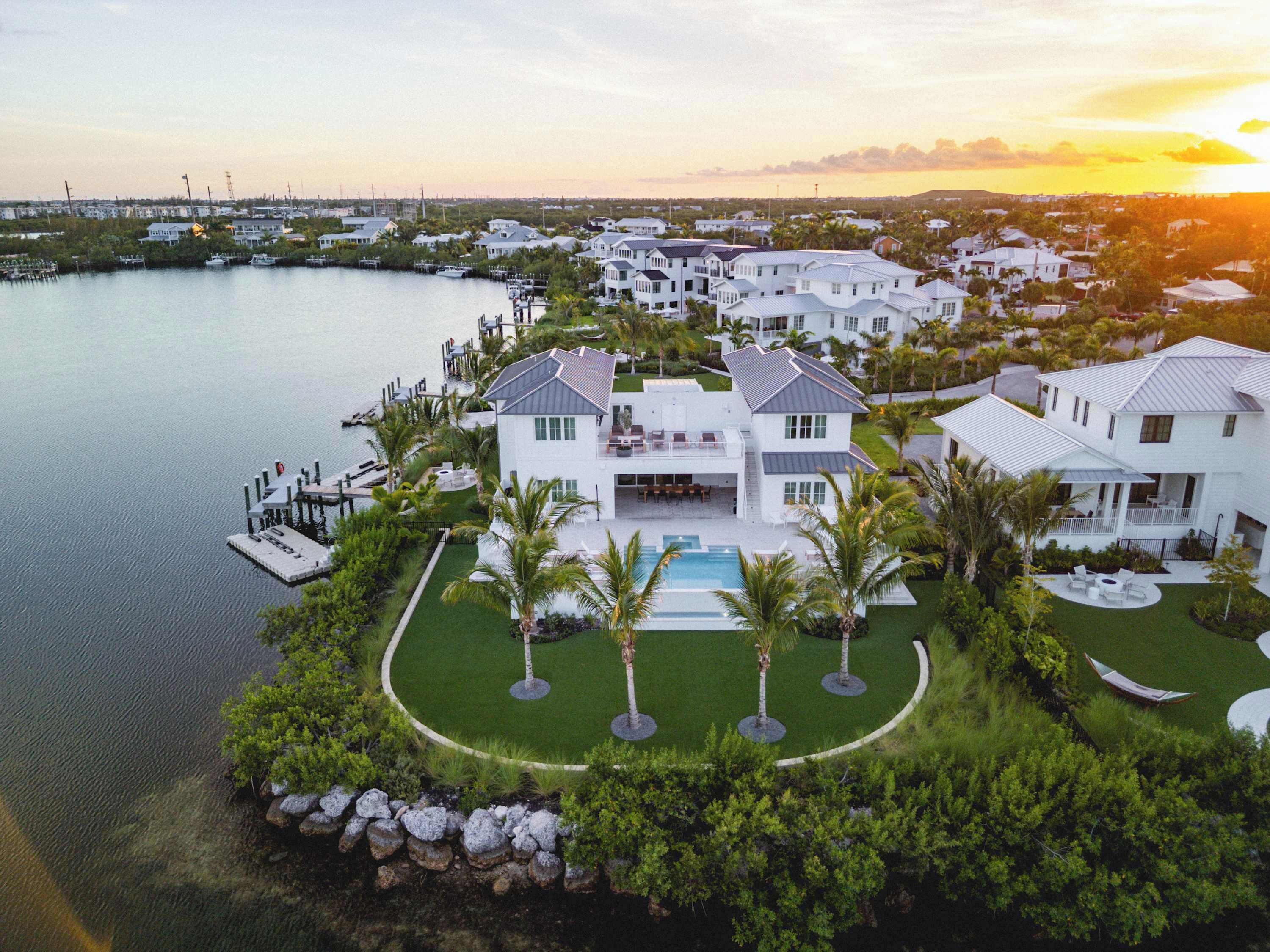A large, modern resort with multiple white buildings, a central pool, and a marina.