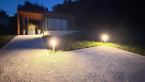 Una casa moderna amb una entrada i dues làmpades exteriors.