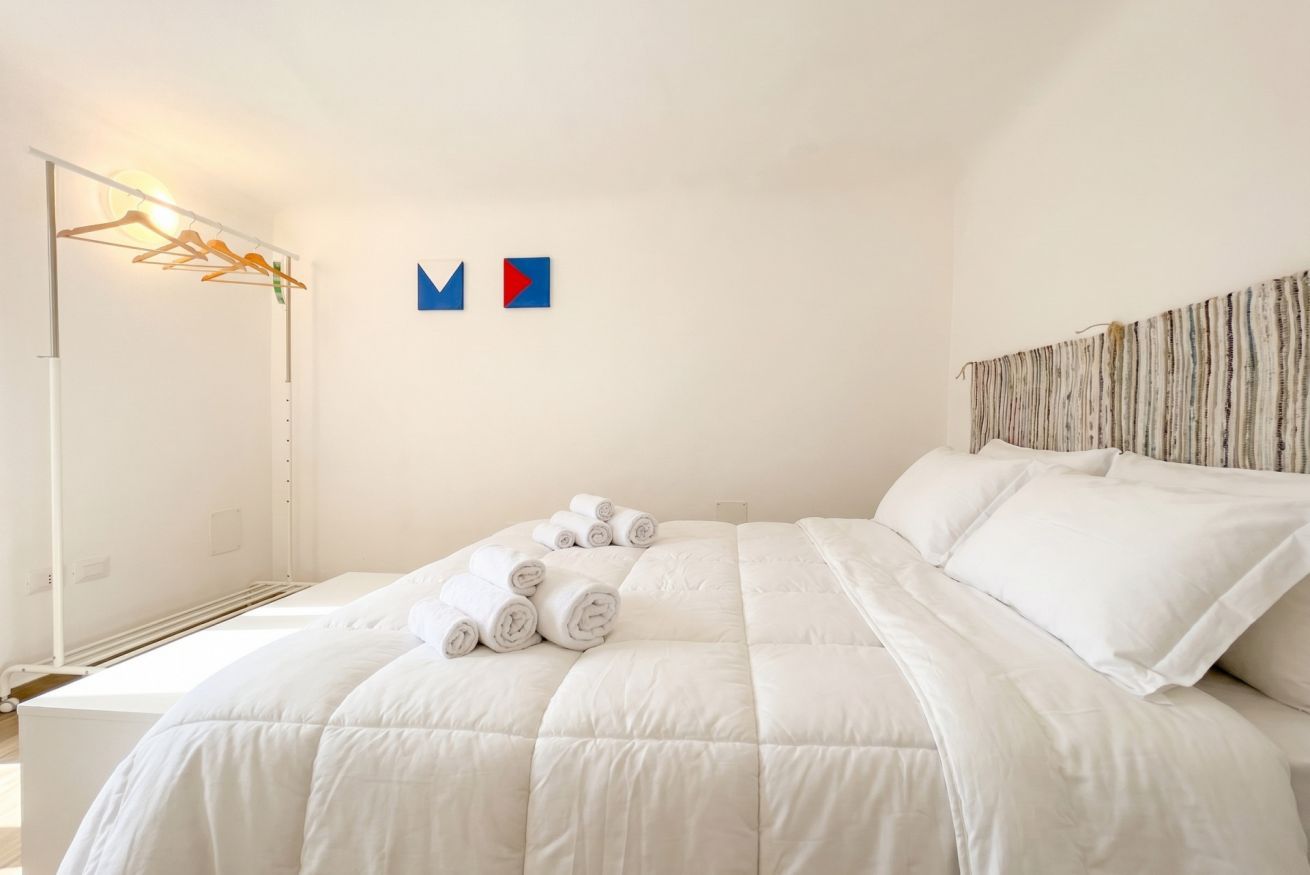 Une chambre d’hôtel avec un lit, un porte-serviettes fixé au mur et un lit avec des serviettes pliées.