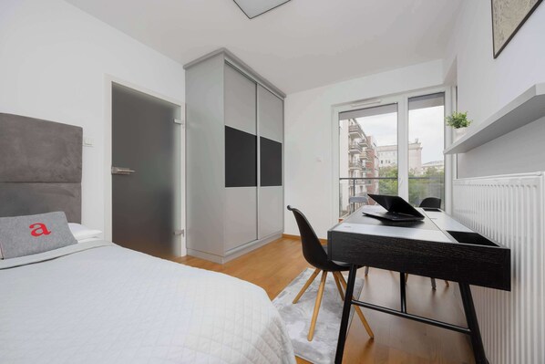 Un dormitorio moderno con cama, escritorio y armario corredero.